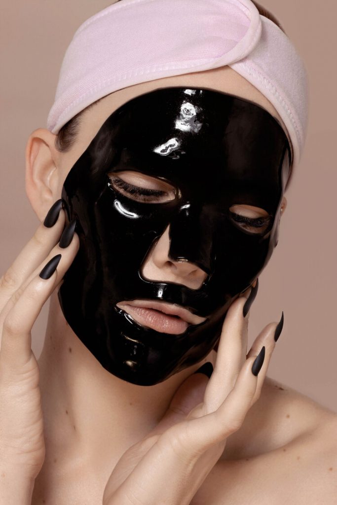Samantha Lear with a black gel face mask and a pink headband.