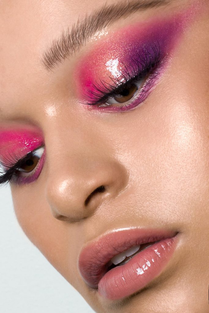Baatile Praet of Devojka Models looking down with glossy pink and purple eyeshadow.