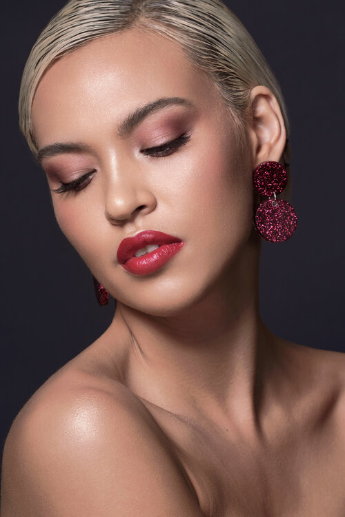 Sinead Carpenter wearing red glitter earrings with a red lip and soft pink eyes.