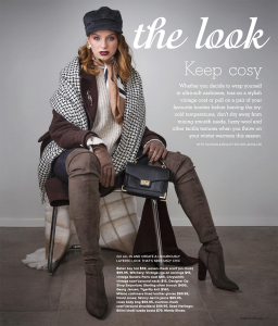 A redheaded model wearing a black cap, knee high velvet boots and various print scarves.