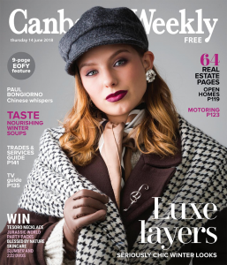 A redheaded model wearing a black cap on the cover of Canberra weekly.
