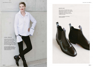 A mature model wearing a white shirt with black pants and boots.