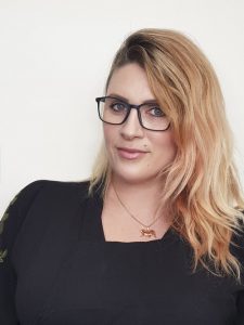 Makeup artist Katie Saarikko in a black top wearing black glasses