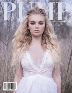 A model with long blonde hair in a white dress.